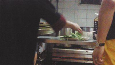 7月23日，漢麗軒烤肉超市昌平店，服務(wù)員將幾盤顧客剩菜（左手中疊在一起的是幾盤肉，其右手正整理韭菜）端回后廚，進行整理后準備再送往餐廳自助取餐區(qū)供顧客食用。